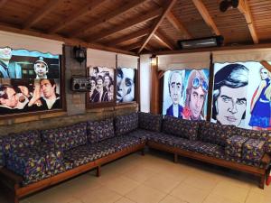 a room with a couch with pictures on the walls at Yeni Bademli Konuk Evi in Gokceada Town