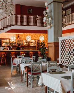 un restaurante con mesas y sillas y un bar en Macara Village Resort en Quba