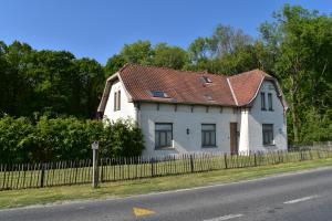 Le Gheer的住宿－Jachthuis Au Bois Du Gheer，路边有红色屋顶的白色房子