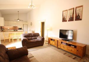 a living room with a couch and a flat screen tv at Pissouri Bay Bungalow in Pissouri