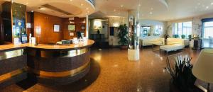 a lobby with a bar in the middle of a building at Best Western Hotel Mediterraneo in Castelldefels