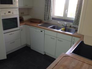 a kitchen with white cabinets and a sink at Villa Sint Anna in Sint Anna ter Muiden