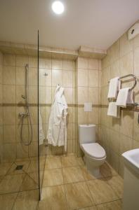 een badkamer met een douche, een toilet en handdoeken bij Floros Simfonija in Šventoji