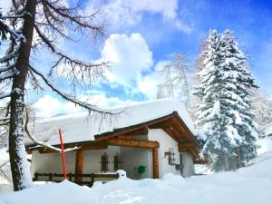 une cabane en rondins avec de la neige sur le toit dans l'établissement Ferienwohnung Sunneschii, à Davos