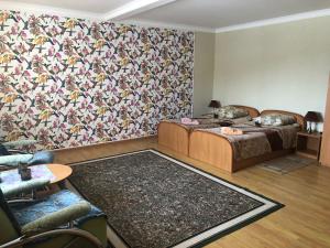 ein Wohnzimmer mit 2 Betten und einem Teppich in der Unterkunft Mini Hotel Furmi in Schidnyzja