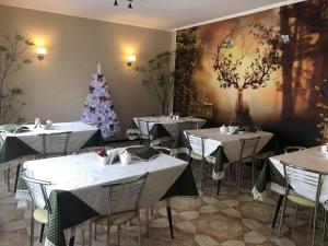 a restaurant with tables and a christmas tree on the wall at Mini Hotel Furmi in Skhidnitsa