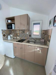 eine Küche mit einer Spüle und einer Arbeitsplatte in der Unterkunft Apartmani Marko in Baška