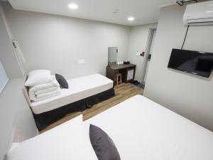 a small room with a bed and a flat screen tv at K-Grand Hostel Gangnam1 in Seoul