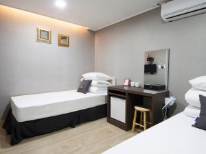 a hotel room with two beds and a desk at K-Grand Hostel Gangnam1 in Seoul