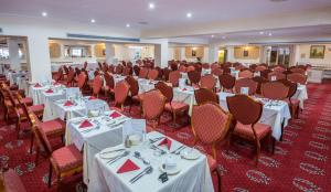 a banquet hall with white tables and chairs at Barrowfield Hotel in Newquay