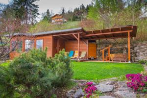 a small cabin with a roof on top of a yard at Happy House Apartments in Špindlerův Mlýn