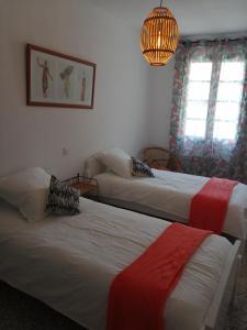 a bedroom with two beds and a chandelier at BEL APPARTEMENT SPACIEUX CENTRE VILLE UZES T3 in Uzès