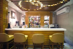 um bar com quatro cadeiras e um balcão num restaurante em The Samilton em Calcutá