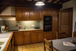 - une cuisine avec des placards en bois et une table dans l'établissement chaumière de l'épine, à La Crique