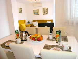 una sala da pranzo con un tavolo con una ciotola di frutta di Apartment Jan a Krk Altre 38 foto
