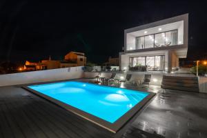 a swimming pool in front of a house at night at Biscuttela Vicentina in Praia da Arrifana