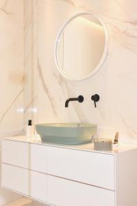 uma casa de banho com um lavatório e um espelho numa cómoda em S'O Suites Tropea em Tropea