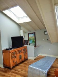 a living room with a tv on a dresser and a window at Blacksmiths in Dartmouth