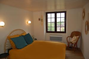 a bedroom with a yellow bed and a window at LOU CLEDOU in Cendrieux