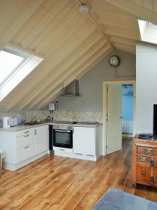 a kitchen with white appliances and a wooden floor at Blacksmiths in Dartmouth