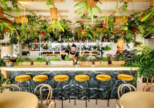 a man standing behind a bar with plants at Assembly Covent Garden in London