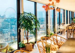 Zimmer mit einem Tisch und Stühlen sowie einem großen Fenster in der Unterkunft Assembly Leicester Square in London