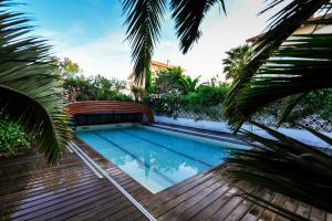 a swimming pool in a backyard with palm trees at La Villa ioanes in Saint-Louis-du-Rhône