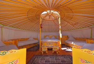 a room with two beds and a tent at Yourte Nomade-Lodge in La Chapelle-Gauthier