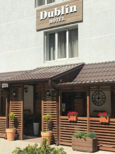 a hotel with potted plants in front of a building at Dublin Hotel in Novorossiysk