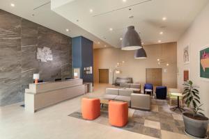 a lobby with a waiting area with orange and blue chairs at Holiday Inn & Suites - Aguascalientes, an IHG Hotel in Aguascalientes