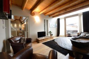 a living room with a table and leather chairs at Hotel Vecchia Stazione Mountain Elegance in Roana