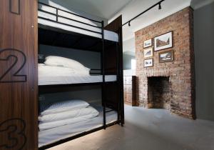 Ce lit superposé noir se trouve dans un dortoir doté d'une cheminée. dans l'établissement PubLove @ The Crown, Battersea, à Londres
