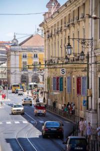 リスボンにあるリスボン アーセナル スイーツの車や建物が並ぶ賑やかな街道