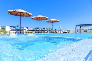 basen z parasolami, stołami i krzesłami w obiekcie Villa Solaris Heated Pool & Jacuzzi w mieście Georgioupolis