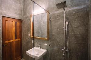 ein Bad mit einer Dusche, einem Waschbecken und einer Dusche in der Unterkunft Timeless villa in Ahangama