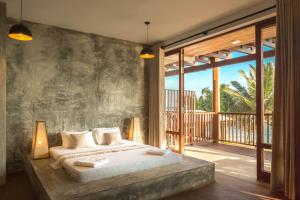 a bedroom with a large bed and a balcony at Timeless villa in Ahangama