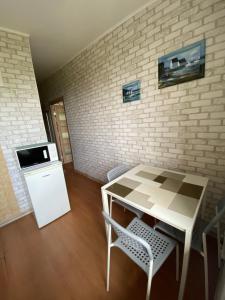 a kitchen with a table and chairs and a brick wall at Apartment on Chernomorskaya 2a in Odesa
