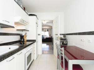 une cuisine avec des placards blancs et un comptoir rouge dans l'établissement Apartamento de 2 dormitorios en Medina Garden, à Marbella