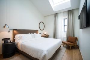 pokój hotelowy z łóżkiem i krzesłem w obiekcie Hotel Arbaso w mieście San Sebastián