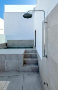 uma escada na casa de banho com um chuveiro e um lavatório em Dormos Hotel em Cádiz