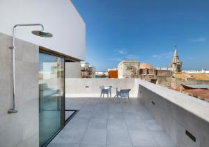 a balcony with a table and chairs on a roof at Dormos Hotel in Cádiz