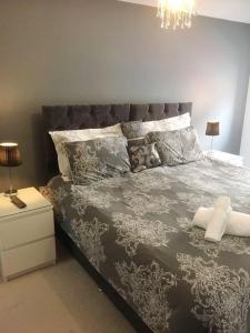 a bedroom with a large bed and a chandelier at Mossie Apartment in Ayr