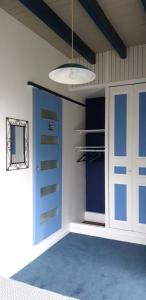 Zimmer mit einem blauen und weißen Schrank und einer Tür in der Unterkunft LE CHALET SUISSE - Chambre bleue in Le Vicel