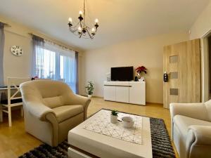 uma sala de estar com duas cadeiras e uma mesa de centro em Apartament Rzeszow Hetmanska em Rzeszów
