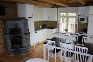 a kitchen with a fireplace and a table and chairs at Saija Lodge in Jokijärvi