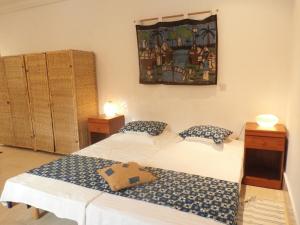 a room with two beds and a picture on the wall at B & B Villa Calliandra in Bijilo