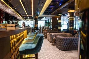 eine Bar mit einer Stuhlreihe in einem Restaurant in der Unterkunft Hammeum Hotel in Prokuplje