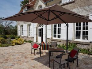 a patio with a table and chairs under an umbrella at la blanchetière in Francueil