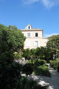 a building in the middle of a garden at Hôtel Les Palmiers in Saint-Tropez