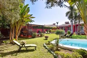 einen Hinterhof mit einem Pool und einem Haus in der Unterkunft Villa Tropycal Golf Maspalomas in Maspalomas